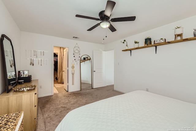 carpeted bedroom with a spacious closet, a closet, and ceiling fan