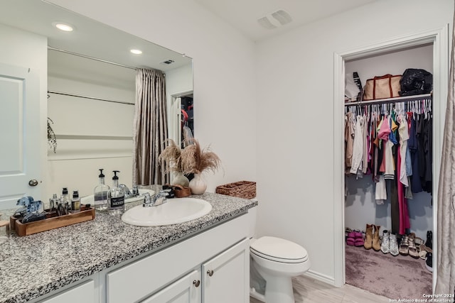 bathroom featuring vanity, hardwood / wood-style floors, and toilet