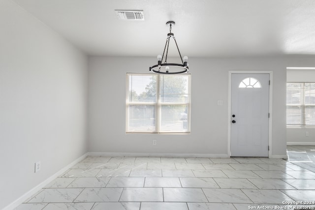 entryway featuring a notable chandelier and plenty of natural light