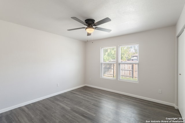 spare room featuring dark hardwood / wood-style floors, a textured ceiling, and ceiling fan