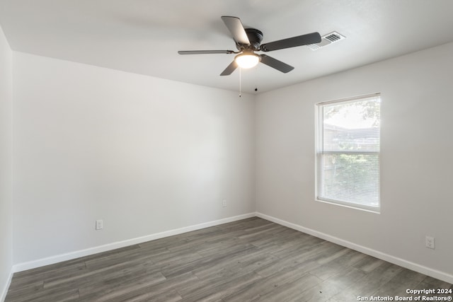 spare room with dark wood-type flooring and ceiling fan