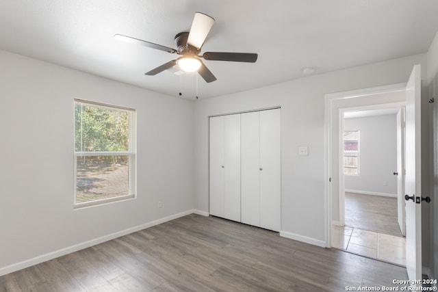 unfurnished bedroom with hardwood / wood-style flooring, ceiling fan, and a closet