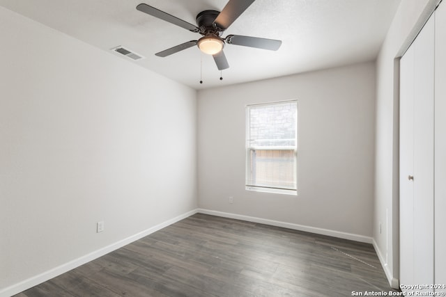 spare room featuring dark wood-type flooring and ceiling fan