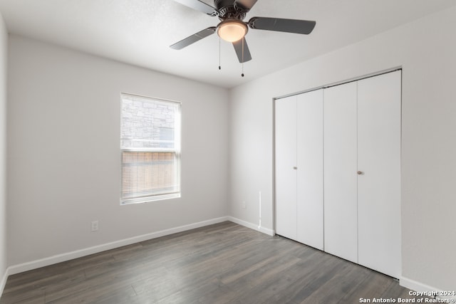 unfurnished bedroom with ceiling fan, dark wood-type flooring, and a closet