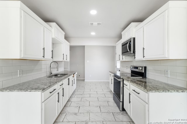 kitchen with stainless steel appliances, white cabinets, sink, and light stone counters