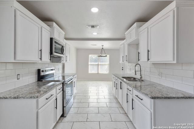 kitchen with appliances with stainless steel finishes, hanging light fixtures, white cabinetry, and sink