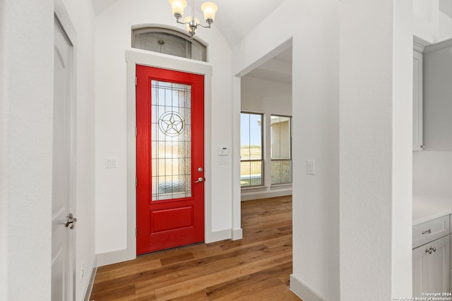 foyer entrance with an inviting chandelier and hardwood / wood-style flooring