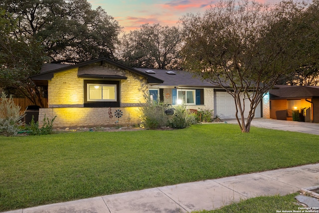 ranch-style house featuring a garage and a yard