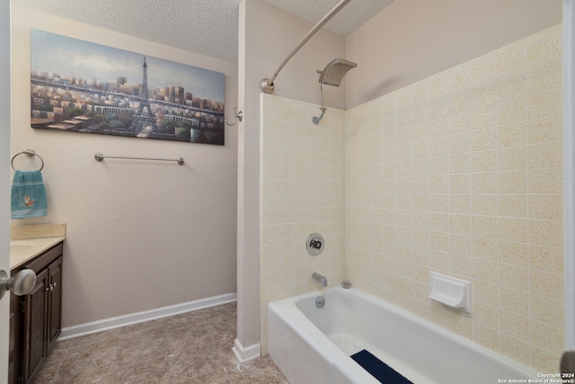 bathroom with tiled shower / bath, tile patterned floors, vanity, and a textured ceiling