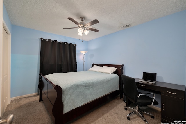 carpeted bedroom featuring a textured ceiling and ceiling fan