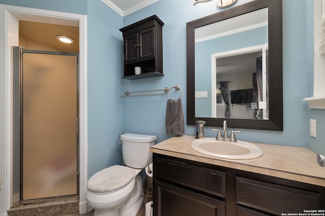 bathroom featuring vanity, crown molding, toilet, and a shower with shower door