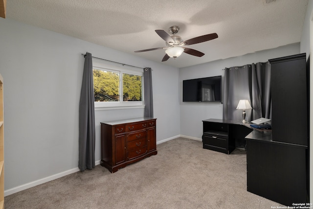 carpeted bedroom with ceiling fan and a textured ceiling