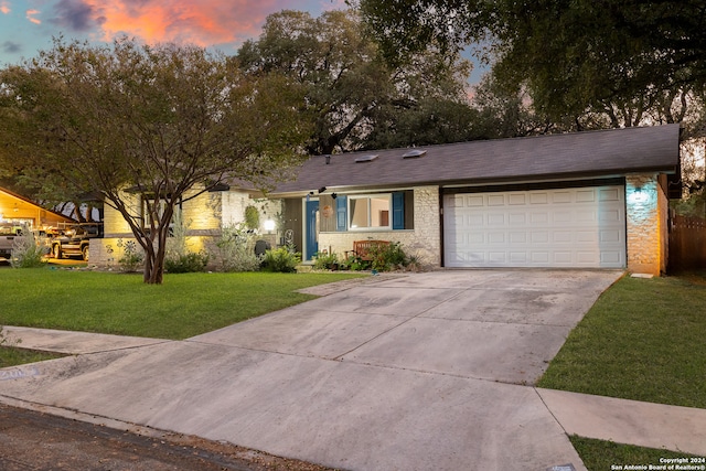 ranch-style house featuring a yard and a garage