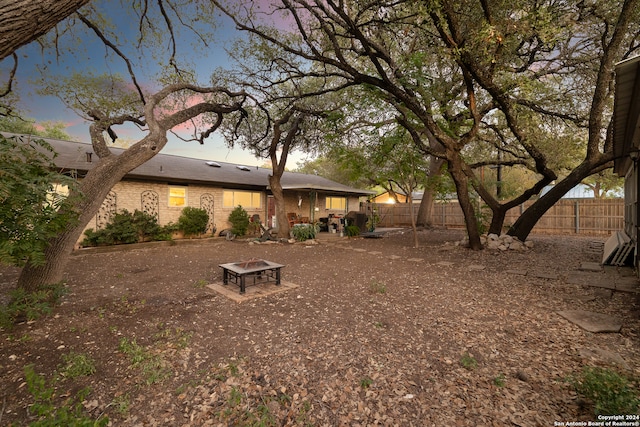 yard at dusk with a fire pit