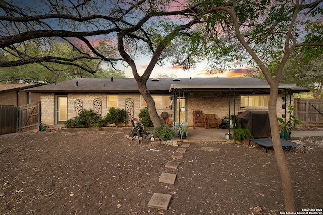 back house at dusk with a patio