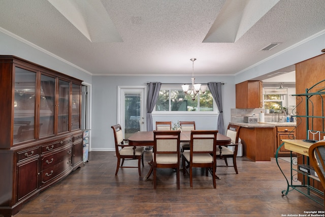 dining area featuring a textured ceiling, a notable chandelier, ornamental molding, and dark hardwood / wood-style flooring