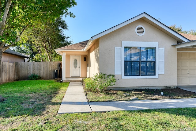 view of front of house with a garage and a front lawn