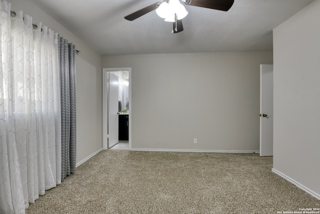 empty room featuring light colored carpet, a textured ceiling, and ceiling fan