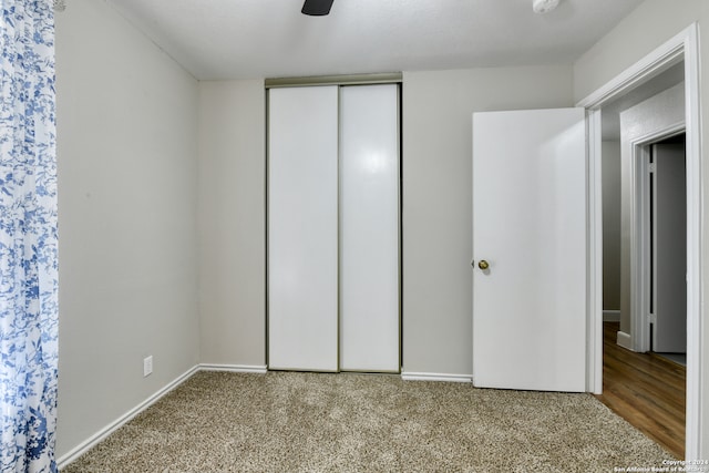 unfurnished bedroom with ceiling fan, a closet, and carpet