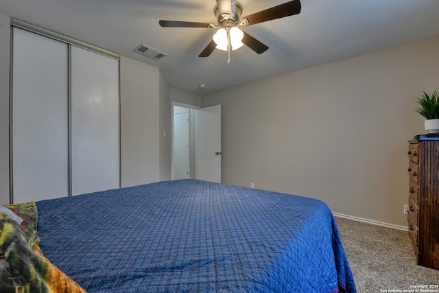 unfurnished bedroom featuring ceiling fan, carpet floors, a closet, and a textured ceiling