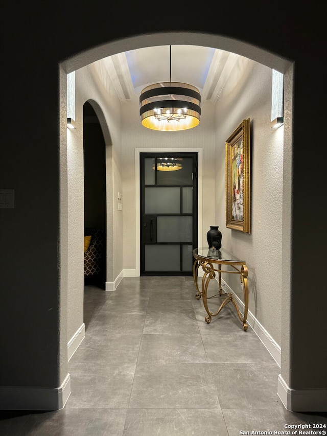 hallway with a notable chandelier and vaulted ceiling