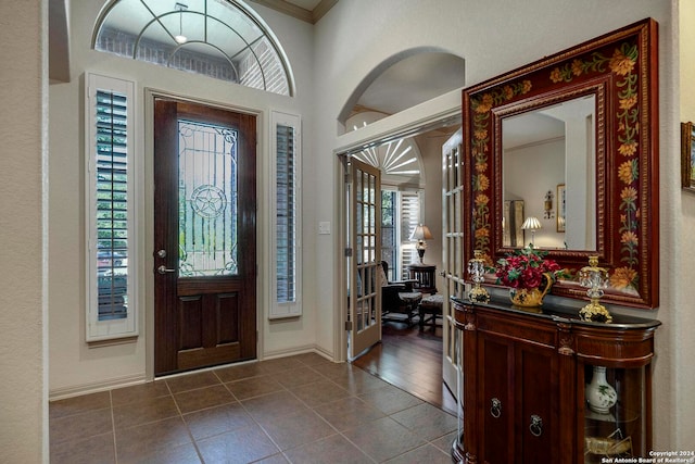 foyer with ornamental molding, plenty of natural light, and dark hardwood / wood-style flooring