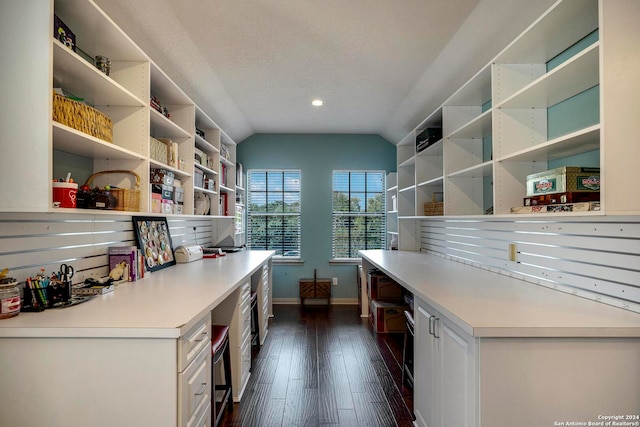 kitchen with dark wood-type flooring, white cabinets, and lofted ceiling