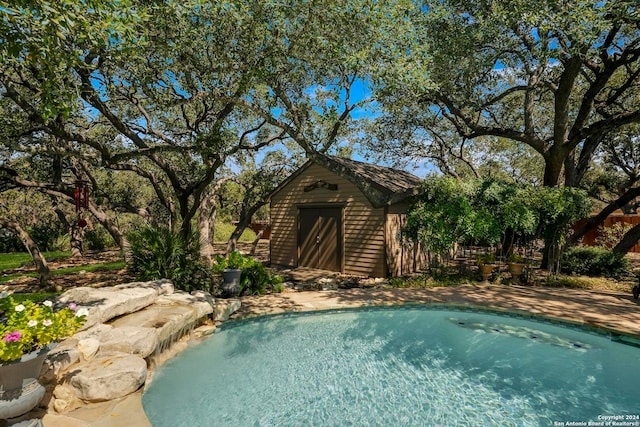 view of pool with an outbuilding