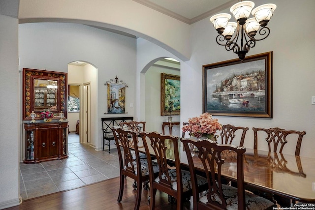 dining space featuring wood-type flooring, a notable chandelier, and ornamental molding