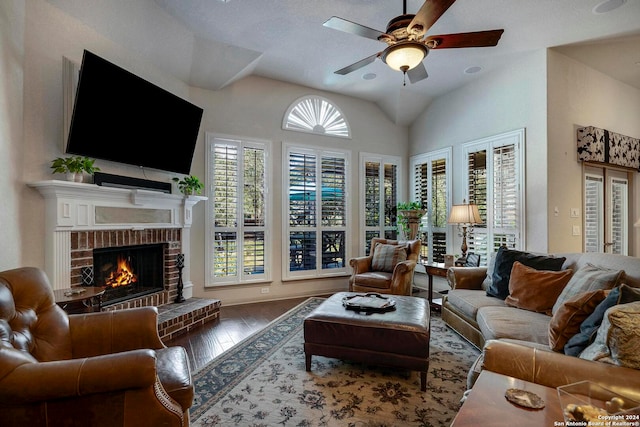 living room featuring lofted ceiling, a brick fireplace, hardwood / wood-style flooring, and ceiling fan