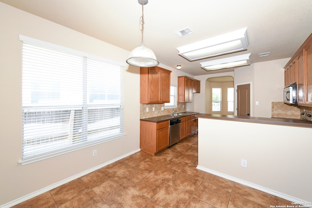 kitchen featuring hanging light fixtures, sink, stainless steel appliances, and backsplash