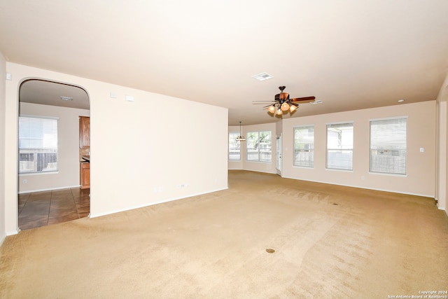 unfurnished living room featuring carpet flooring and ceiling fan