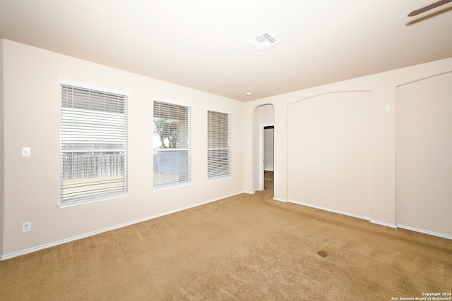 carpeted spare room featuring ceiling fan