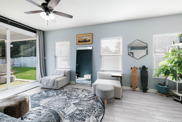 living area with light wood-type flooring, a healthy amount of sunlight, and ceiling fan