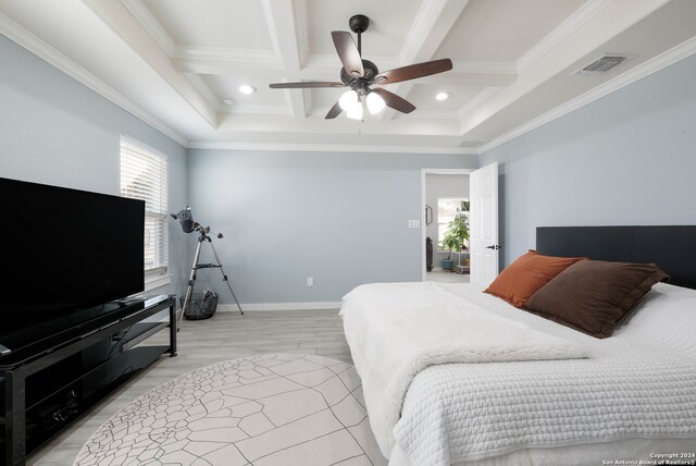 bedroom with ceiling fan, beam ceiling, ornamental molding, coffered ceiling, and light hardwood / wood-style floors