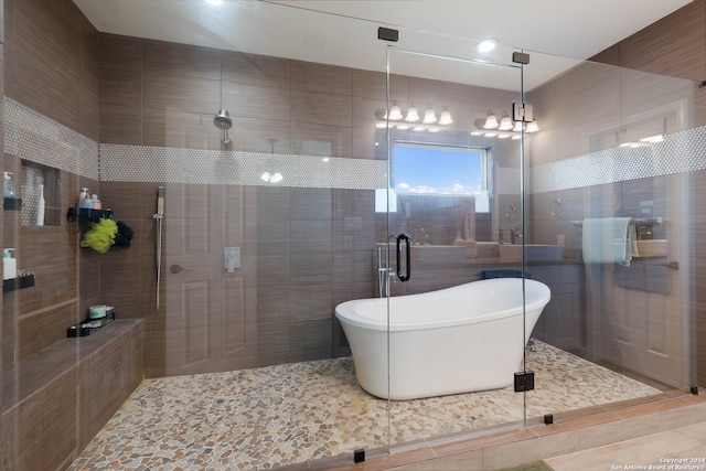 bathroom featuring tile patterned floors, separate shower and tub, and tile walls