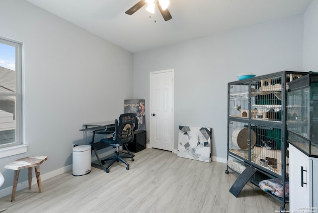 office with light wood-type flooring and ceiling fan