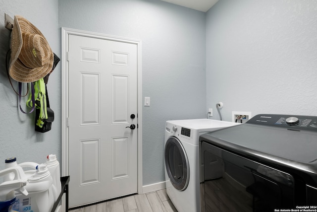 laundry room featuring washing machine and dryer and light hardwood / wood-style floors