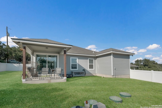 rear view of property with a yard and a patio