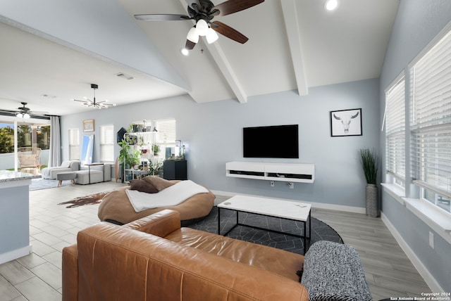 living room with ceiling fan with notable chandelier, light hardwood / wood-style flooring, and lofted ceiling with beams