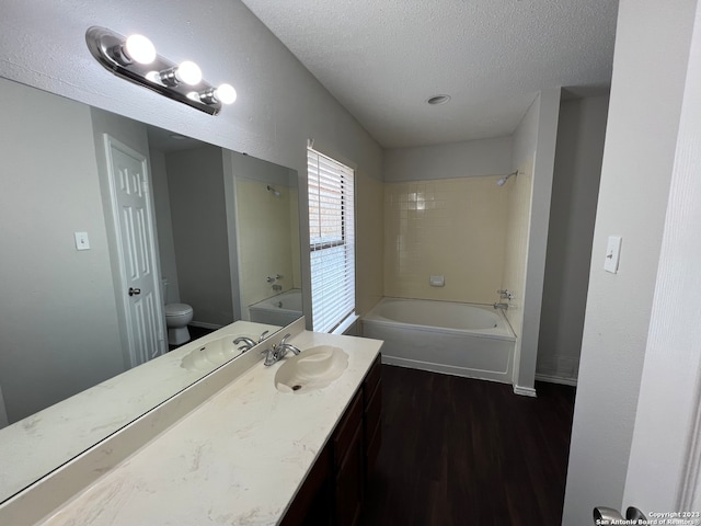 full bathroom featuring hardwood / wood-style floors, vanity, toilet, and tiled shower / bath combo