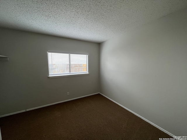 carpeted empty room featuring a textured ceiling