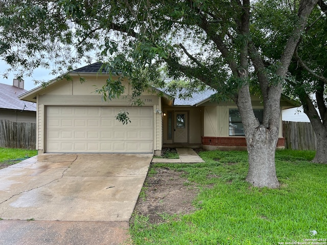 single story home featuring a garage and a front lawn