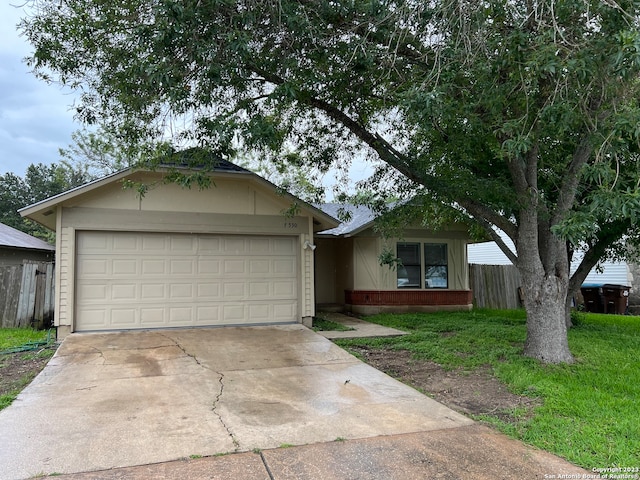 ranch-style home with a garage and a front lawn