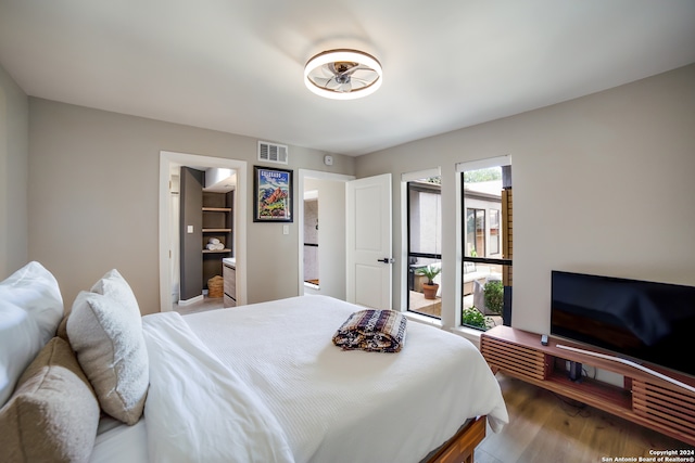 bedroom with hardwood / wood-style floors and a spacious closet