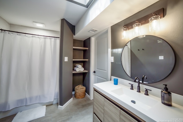 bathroom featuring a skylight, vanity, and a shower with curtain