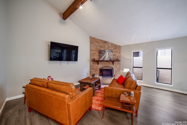 living room with lofted ceiling with beams, a fireplace, hardwood / wood-style floors, and a textured ceiling