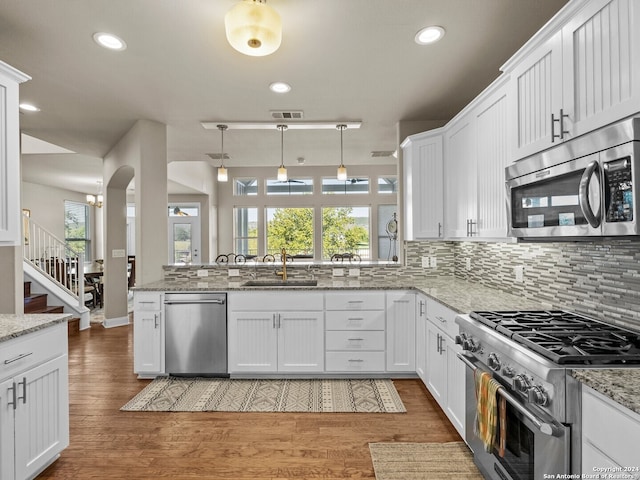 kitchen with stainless steel appliances, plenty of natural light, sink, and white cabinetry