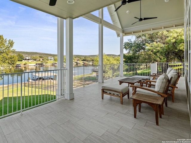 view of patio with a water view and ceiling fan