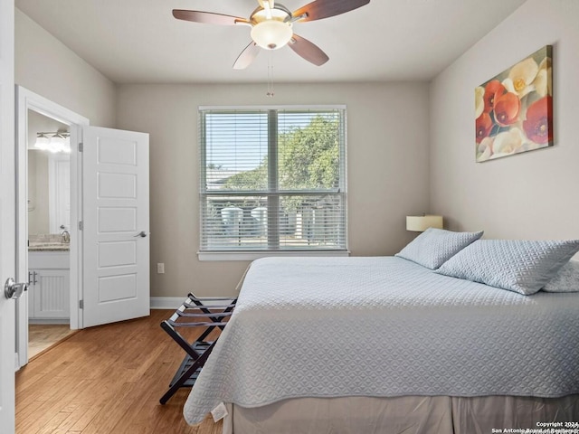 bedroom with ensuite bath, light hardwood / wood-style flooring, and ceiling fan